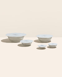 The Studio 5 Piece Suction Lid set covering glass bowls on a cream background. 