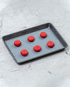 The Slate 9 x 12 Baking mat on a tray with red macaroons on it. 