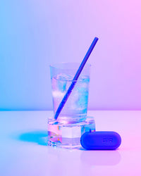 The GIR Straw in a glass of Ice water on a colorful background. 