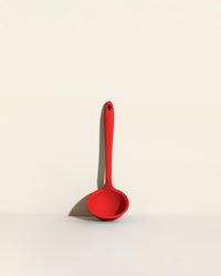 The Red Ultimate Ladle on a cream background. 
