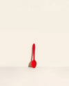 The Red Mini Spoon on a cream background. 