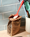 The GIR Red Spoon taking flour out of a bag with other GIR tools on to its right. 